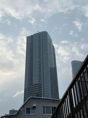 a tall skyscraper with a building in the background at EKVOLI ROPPONGI TOKYO, Private Hotel in Tokyo