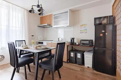 a kitchen with a table and chairs and a refrigerator at Clover House in Tokyo
