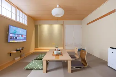 a dining room with a table and a tv at Clover House in Tokyo