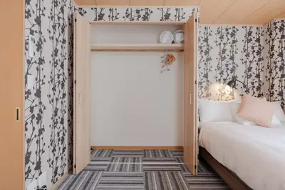 a small bedroom with a bed and a window at Clover House in Tokyo
