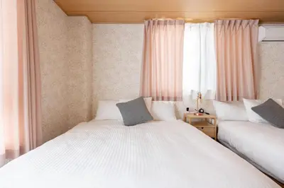 a bedroom with two beds and a window at Clover House in Tokyo
