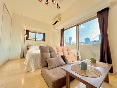 a living room with a couch and a bed at Shinjuku-Okubo Cozy Double, Free Wi-Fi in Tokyo