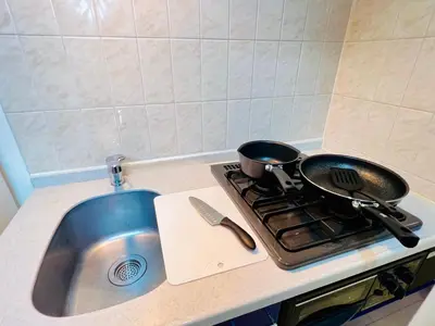 a kitchen sink with a frying pan on a stove at Shinjuku-Okubo Cozy Double, Free Wi-Fi in Tokyo