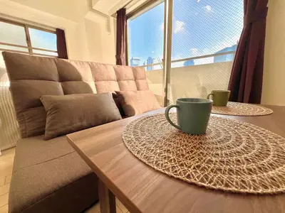 a coffee table with a coffee cup on it in front of a couch at Shinjuku-Okubo Cozy Double, Free Wi-Fi in Tokyo