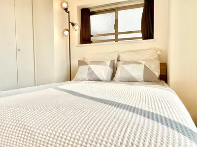 a white bed with white pillows and a window at Shinjuku-Okubo Cozy Double, Free Wi-Fi in Tokyo