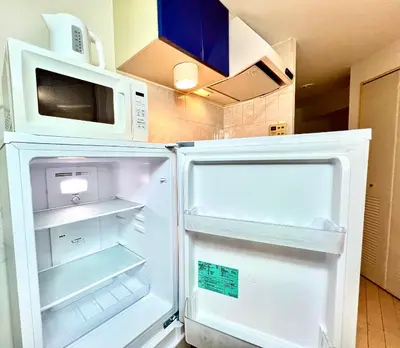 an open refrigerator with a microwave on top of it at Shinjuku-Okubo Cozy Double, Free Wi-Fi in Tokyo