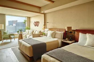 a hotel room with two beds and a living room at 1 Hotel Tokyo in Tokyo