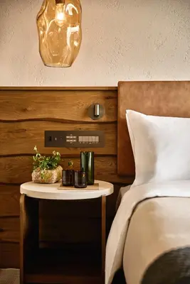 a hotel room with a bed and a nightstand with a table at 1 Hotel Tokyo in Tokyo