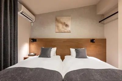 two beds in a hotel room with two beds sidx sidx sidx at Tokyo Waseda Base in Tokyo