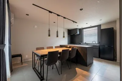 a kitchen with a wooden table and chairs in it at Tokyo Waseda Base in Tokyo