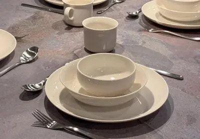 a table with plates and cups and forks and spoons at Tokyo Waseda Base in Tokyo