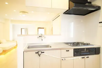 a white kitchen with a sink and a stove at SIC Hotel Shinjuku - Shin Nakano in Tokyo