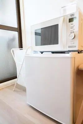 a microwave sitting on top of a white refrigerator at SIC Hotel Shinjuku - Shin Nakano in Tokyo