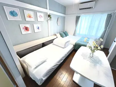a small room with two beds and a table at Chelsea Hatsudai 202 CH22 in Tokyo