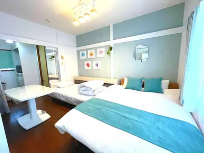 a room with two beds and a table in it at Chelsea Hatsudai 202 CH22 in Tokyo