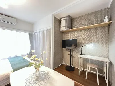 a bedroom with a bed and a desk and a tv at Chelsea Hatsudai 202 CH22 in Tokyo