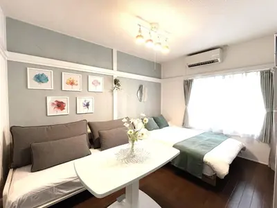 a bedroom with a bed and a couch and a table at Chelsea Hatsudai 202 CH22 in Tokyo