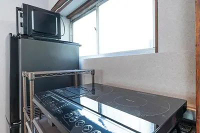 a kitchen with a stove top oven with a microwave at \u9418\u30f6\u6df5Stay in Tokyo