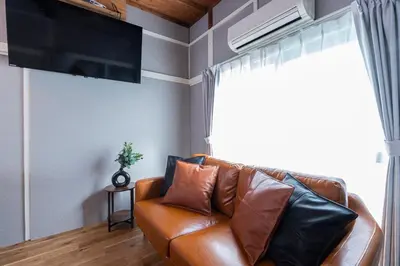 a brown leather couch in a living room with a window at \u9418\u30f6\u6df5Stay in Tokyo