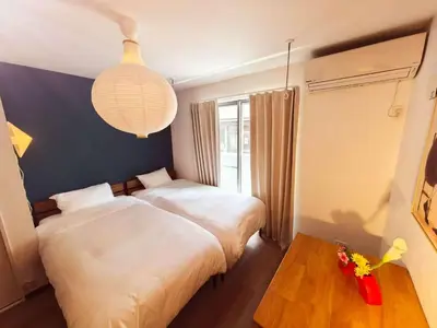 a bedroom with two beds and a table and a lamp at Mossy Nest Negishi I \u9daf\u8c37\u99c5\u5f92\u6b697\u5206 \u4e0a\u91ce\u5f92\u6b69\u570f\u5185 in Tokyo