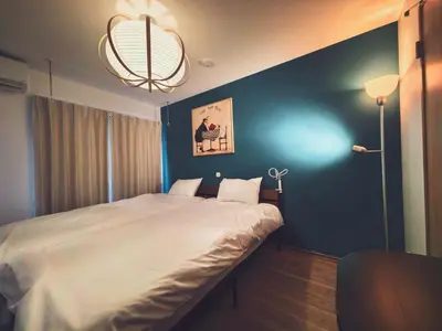 a bedroom with a large bed with a blue wall at Mossy Nest Negishi I \u9daf\u8c37\u99c5\u5f92\u6b697\u5206 \u4e0a\u91ce\u5f92\u6b69\u570f\u5185 in Tokyo