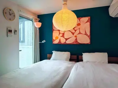 a bedroom with two white beds and a chandelier at Mossy Nest Negishi I \u9daf\u8c37\u99c5\u5f92\u6b697\u5206 \u4e0a\u91ce\u5f92\u6b69\u570f\u5185 in Tokyo