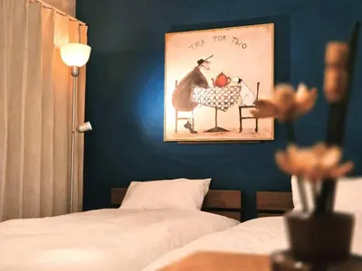 a bedroom with a painting of a man sitting at a table with apples at Mossy Nest Negishi I \u9daf\u8c37\u99c5\u5f92\u6b697\u5206 \u4e0a\u91ce\u5f92\u6b69\u570f\u5185 in Tokyo