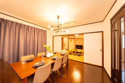 a dining room with a wooden table and chairs at Haleluana SHIBAMATA in Tokyo