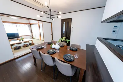 a dining room with a wooden table and chairs at Haleluana SHIBAMATA in Tokyo