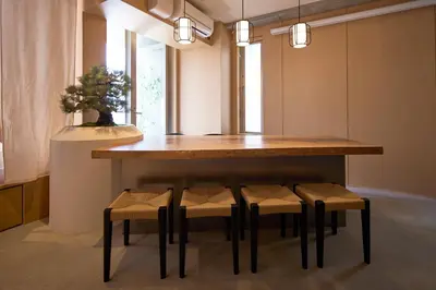 a dining room table with four stools under it at Tsubomi Shibuya in Tokyo