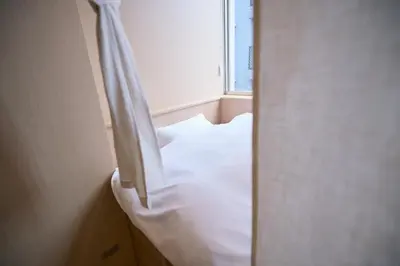 a white bed in a room with a window at Tsubomi Shibuya in Tokyo