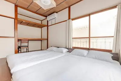 a bedroom with a large white bed with windows at Ymn\u5c0f\u83c52\u4e01\u76ee in Tokyo