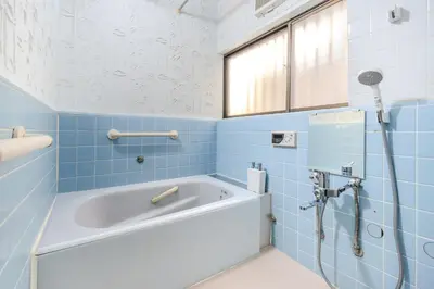 a blue bathroom with a tub and a shower at Kasai Cozy House in Tokyo