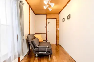 a living room with a chair and a window at Kasai Cozy House in Tokyo