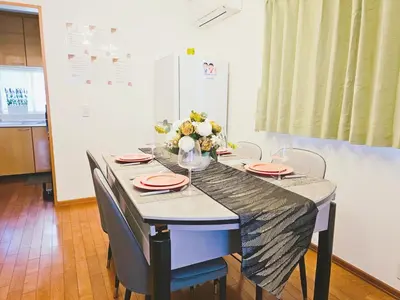a dining room table with plates and flowers on it at 3\u5c64\u4e00\u8ed2\u5bb6\u5b8c\u5168\u8cb8\u5207 \u4ef2\u5bbf\u5546\u5e97\u8857\u5f92\u6b691\u5206 \u6700\u592713\u4eba in Tokyo