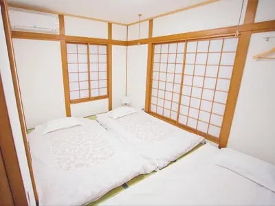 two beds in a room with two windows at 3\u5c64\u4e00\u8ed2\u5bb6\u5b8c\u5168\u8cb8\u5207 \u4ef2\u5bbf\u5546\u5e97\u8857\u5f92\u6b691\u5206 \u6700\u592713\u4eba in Tokyo