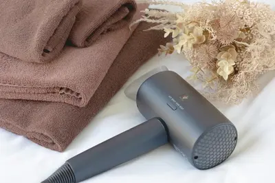 a hair dryer sitting next to a towel and a comb at Akari HOTEL in Tokyo
