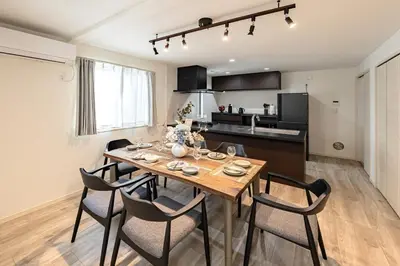 a kitchen and dining room with a wooden table and chairs at Akari HOTEL in Tokyo