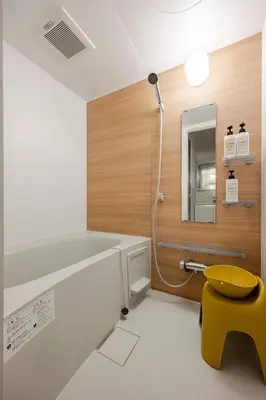 a bathroom with a shower and a yellow stool at sMS\u8db3\u7acb2\u4e01\u76ee in Tokyo