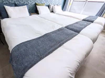 two beds with white sheets and a gray blanket at Near Shibuya Station Dogenzaka 3Beds Travel Work in Tokyo