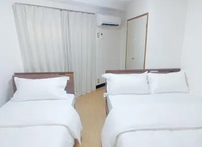 two beds in a room with white sheets and pillows at 2F 3 minutes walk from Nishi-Oi Station, Shinagawa Ward, 4 stations available, surrounded by commercial streets, rich life, convenient transportation in Tokyo