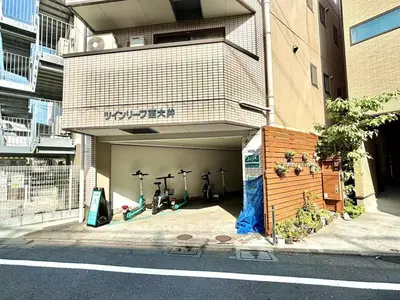 a building with a garage with four bikes in it at 3F 3 minutes walk from Nishi-Oi Station, Shinagawa Ward, 4 stations available, surrounded by commercial streets, rich life, convenient transportation in Tokyo