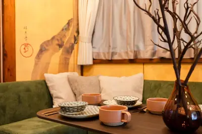 a table with cups and plates and a vase on a couch at EDO GATEI Sakura Biyori Stay in Tokyo