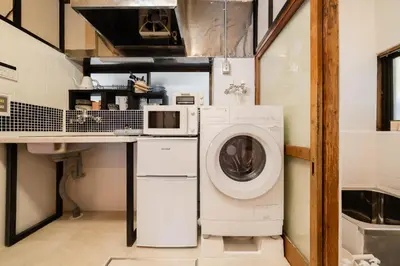 a laundry room with a washer and a microwave at EDO GATEI Sakura Biyori Stay in Tokyo