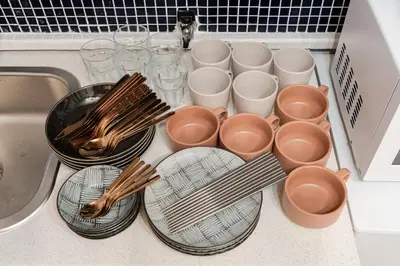 a kitchen counter with plates and bowls and utensils at EDO GATEI Sakura Biyori Stay in Tokyo