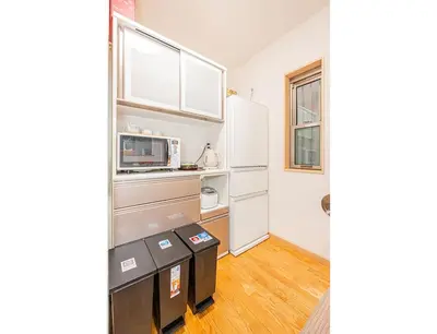a kitchen with white cabinets and a refrigerator at Anzu 4 Bed rooms Villa 5 minutes walk from Keise line Edogawa station in Tokyo