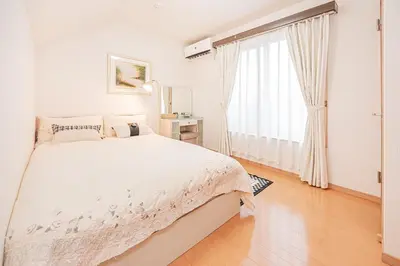 a white bedroom with a bed and a large window at Anzu 4 Bed rooms Villa 5 minutes walk from Keise line Edogawa station in Tokyo