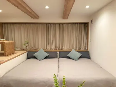 a bedroom with a bed with blue pillows at Akatsuki Ueno Park \u4e0a\u91ce\u52d5\u7269\u5712 \u4e0a\u91ce\u516c\u5712\u5f92\u6b69 4\u5206 in Tokyo