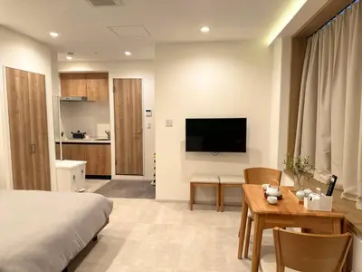 a bedroom with a bed and a table and a television at Akatsuki Ueno Park \u4e0a\u91ce\u52d5\u7269\u5712 \u4e0a\u91ce\u516c\u5712\u5f92\u6b69 4\u5206 in Tokyo