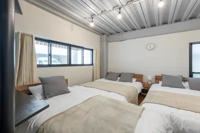 a room with four beds in it with a clock on the wall at Funabori in Tokyo
